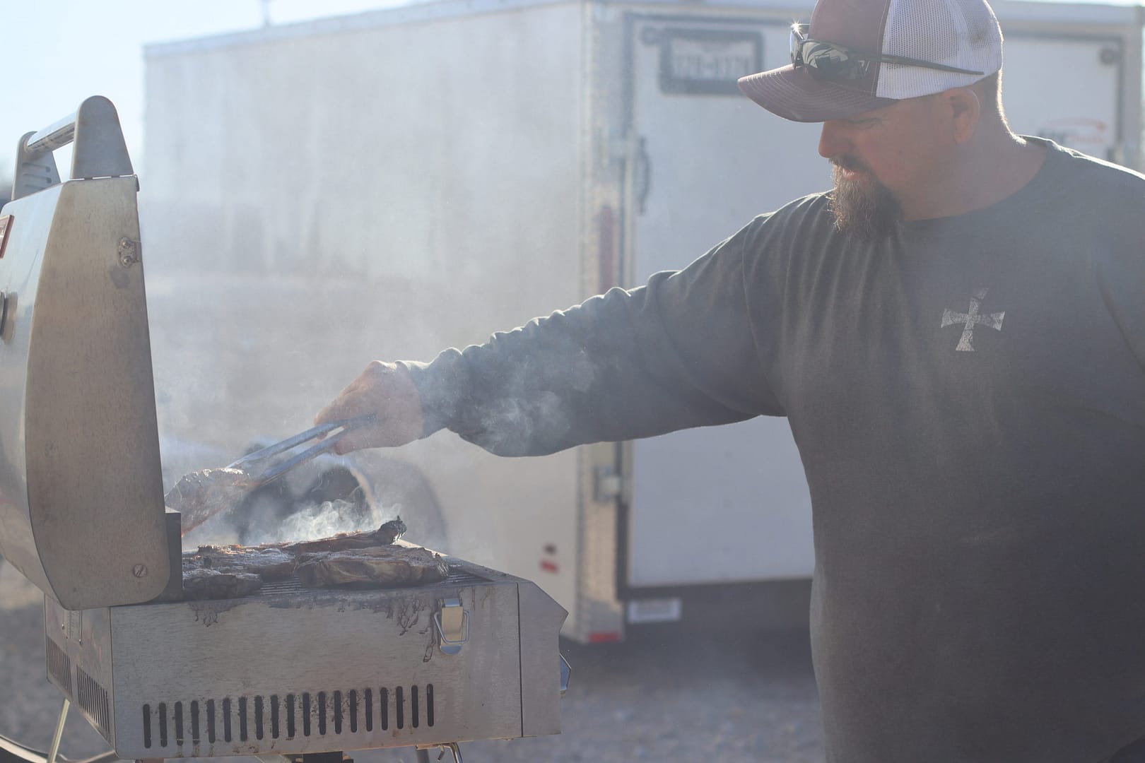 A man cooking on an outdoor grill. A man cooking on an outdoor grill.