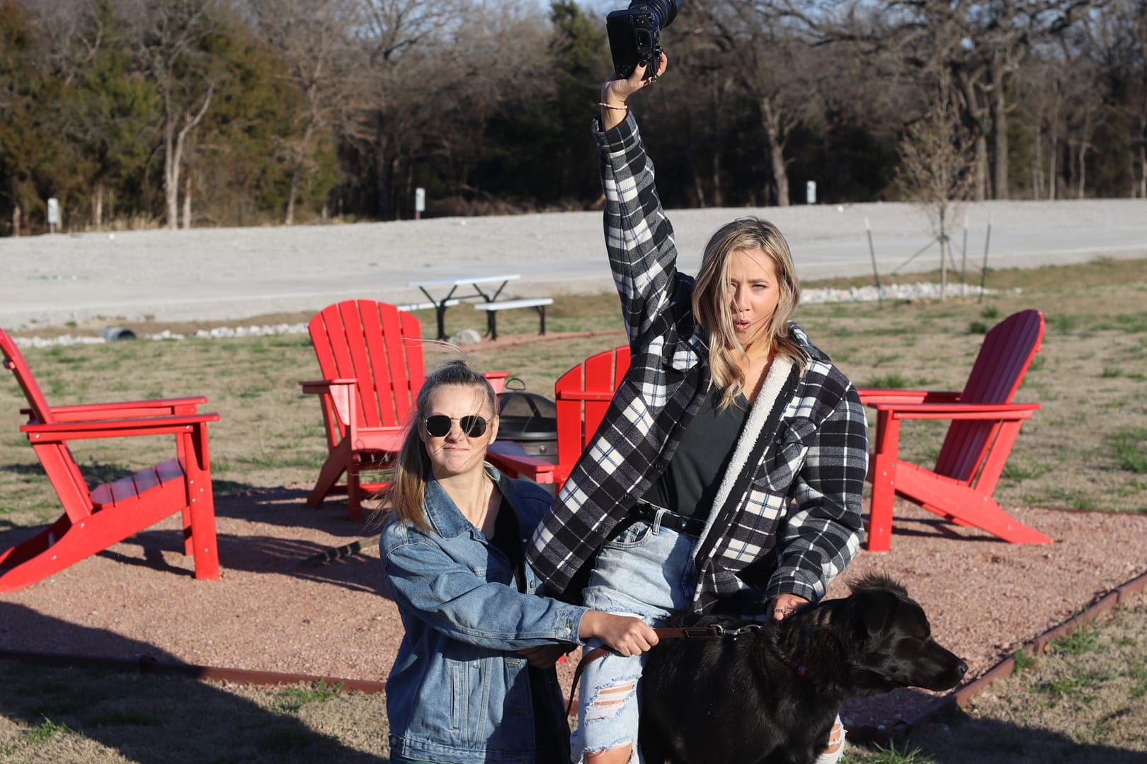 A woman and man holding up a black dog. A woman and man holding up a black dog.