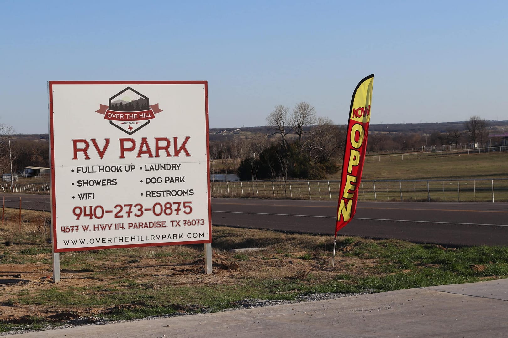 A sign for the rv park is posted next to an open flag. A sign for the rv park is posted next to an open flag.