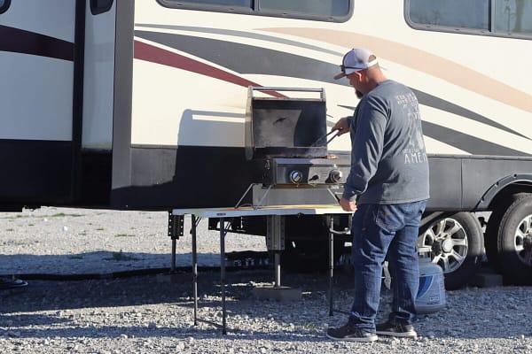 A man cooking food on an outdoor grill.